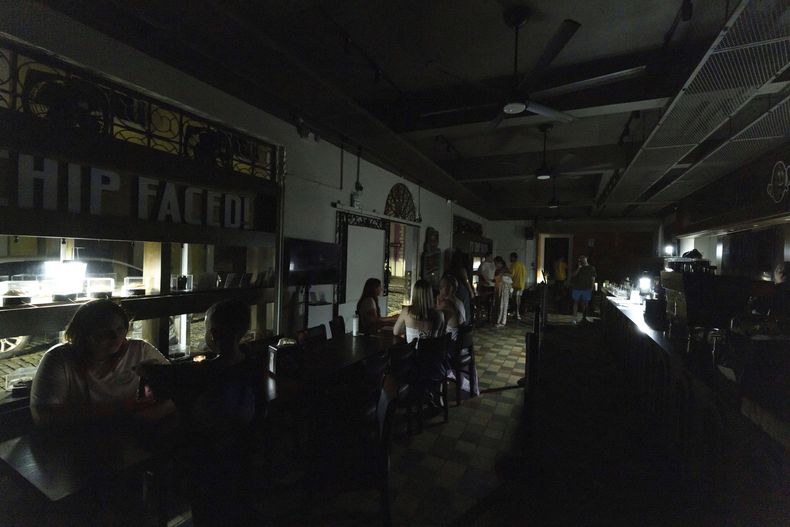 ARCHIVO - Comensales son atendidos en un restaurante iluminado con linternas de batería durante un apagón en toda la isla, en el Viejo San Juan, Puerto Rico, el 16 de abril de 2025. (AP Foto/Alejandro Granadillo, archivo)