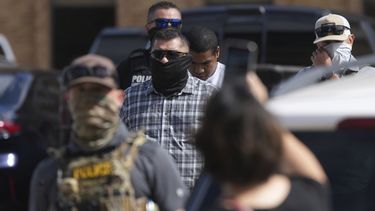 Agentes federales escoltan a un hombre a un autobús después de ser detenido después de una comparecencia en la corte de inmigración, el lunes 28 de julio de 2025, en San Antonio. (AP Foto/Eric Gay)