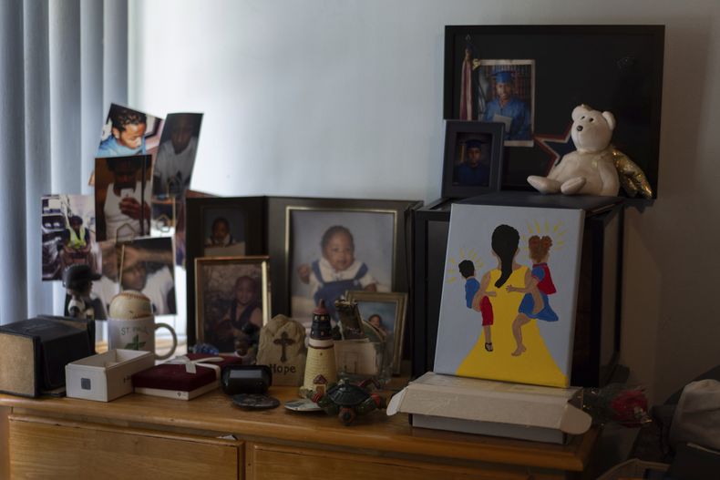 Fotos del hijo de Delphine Cherry, Tyler Randolph, y un cuadro pintado por ella de una madre sosteniendo a dos hijos, sobre una cómoda en su casa, el 5 de septiembre de 2025, en Hazel Crest, Illinois. (AP Foto/Carolyn Kaster)