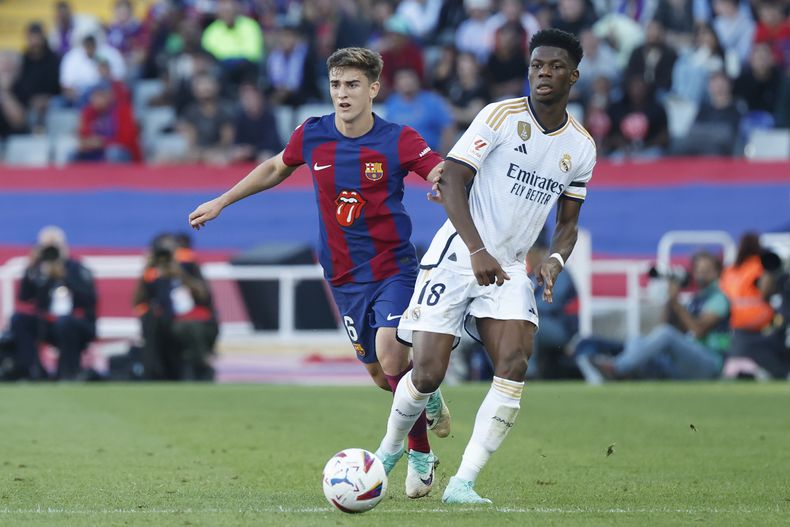 Gavi (izquierda) del Barcelona y Aurelien Tchouameni del Real Madrid durante el partido de la Liga española, el sábado 28 de octubre de 2023, en Barcelona. (AP Foto/Joan Monfort)