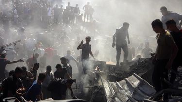 Palestinos inspeccionan los restos de edificios destruidos tras ataques aéreos israelíes sobre la ciudad de Khan Younis, en el sur de la Franja de Gaza, el 26 de octubre de 2023. (AP Foto/Mohammed Dahman)