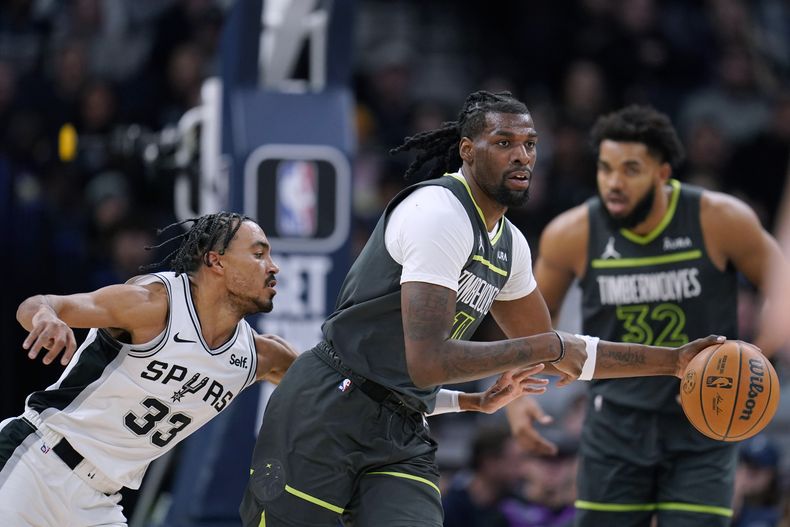 Naz Reid, de los Timberwolves de Minnesota, es defendido por Tre Jones (33), de los Spurs de San Antonio, durante la primera mitad del juego de baloncesto de la NBA, el miércoles 6 de diciembre de 2023, en Minneapolis. (AP Foto/Abbie Parr)