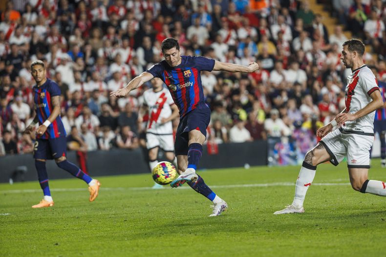 Robert Lewandowski del Barcelona tira para anotar el primer gol del Barcelona ante el Rayo Vallecano en la liga española el miércoles 26 de abril del 2023. (AP Foto/Pablo Garcia)
