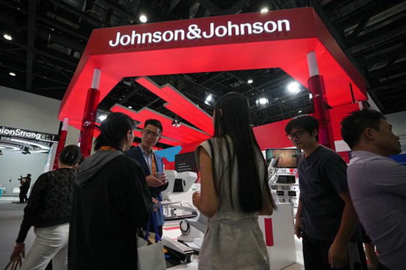 Visitantes pasan por un puesto de Johnson & Johnson, que promociona maquinaria médica durante la Feria Internacional china de Comercio en Servicios, en el recinto de Shougang, Beijing, el miércoles 9 de septiembre de 2026. (AP Foto/Andy Wong)