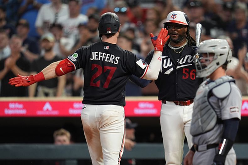 Ryan Jeffers (27), de los Mellizos de Minnesota, calebra con Josh Bell (56) después de batear un cuadrangular solitario durante la séptima entrada del juego de béisbol de Grandes Ligas ante los Tigres de Detroit, el lunes 31 de agosto de 2026, en Minneapolis. (AP Foto/Abbie Parr)