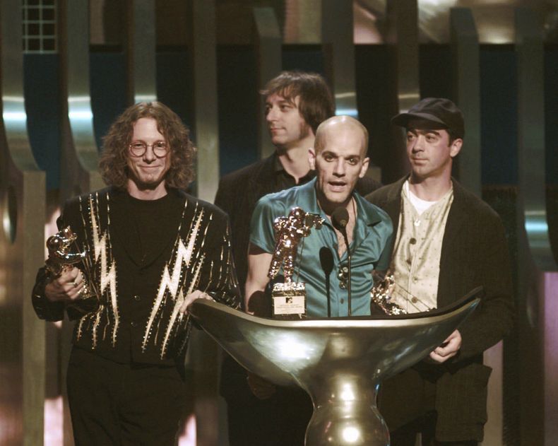 ARCHIVO - Michael Stipe, de la banda R.E.M., centro, al recibir el premio Video Vanguard en los Premios MTV a los Videos Musicales en Radio City Music Hall en Nueva York el 7 de septiembre de 1995. De izquierda a derecha el resto de los integrante de R.E.M., Mike Mills, Peter Buck y Bill Berry. Hace 25 años R.E.M. lanzó Up el primer álbum de la banda sin Berry. (Foto AP/Bebeto Matthews, archivo)