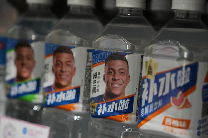 Botellas con bebidas de electrolitos de Dongpeng con la imagen del futbolista francés Kylian Mbappé en un supermercado de Beijing, el martes 27 de octubre de 2026. (AP Foto/Andy Wong)