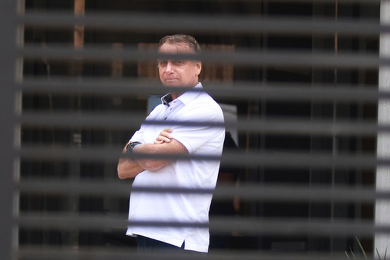 ARCHIVO – El expresidente brasileño Jair Bolsonaro en la entrada de su casa mientras cumple su condena de arresto domiciliario en Brasilia, Brasil, el 2 de septiembre de 2025. (AP Foto/Luis Nova, Archivo)