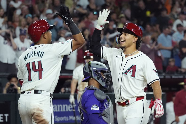 Alek Thomas, derecha, de los Diamondbacks de Arizona, celebra su cuadrangular de tres carreras contra los Rockies de Colorado, con su compañero Gabriel Moreno (14) durante la sexta entrada del juego de béisbol del viernes 29 de marzo de 2024, en Phoenix. (AP Foto/Ross D. Franklin)
