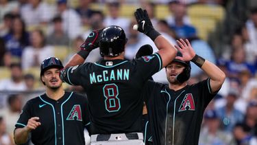 James McCann, centro, de los Diamondbacks de Arizona, es felicitado por Nolan Arenado, izquierda, y Tim Tawa después de batear un cuadrangular de tres carreras durante la sexta entrada del juego de béisbol de Grandes Ligas contra los Dodgers de Los Ángeles, el sábado 11 de julio de 2026, en Los Ángeles. (AP Foto/Mark J. Terrill)
