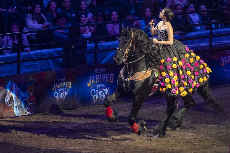 Ángela Aguilar, hija de Pepe Aguilar, monta un caballo al cantar en el espectáculo Jaripeo hasta los huesos tour 2024 en el Honda Center en Anaheim, California, el viernes 29 de marzo de 2024. El espectáculo rinde homenaje al Día de Muertos, una conocida celebración mexicana. (Foto AP/Damian Dovarganes) . (AP Photo/Damian Dovarganes)