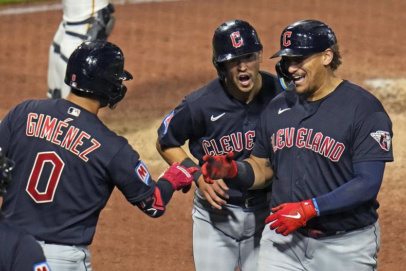 Josh Naylor (derecha), de los Guardianes de Cleveland, festeja con Andrés Giménez y Steven Kwan, luego de conectar un jonrón de dos carreras ante los Piratas de Pittsburgh, el lunes 17 de julio de 2023 (AP Foto/Gene J. Puskar)