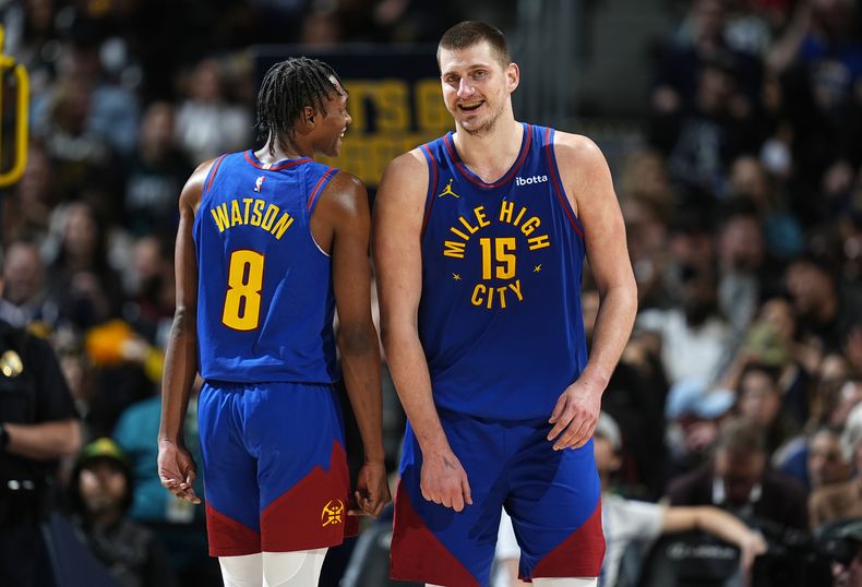 Peyton Watson (izquierda) y Nikola Jokic, de los Nuggets de Denver, bromean en el partido del viernes 2 de febrero de 2024, ante los Trail Blazers de Portland (AP Foto/David Zalubowski)
