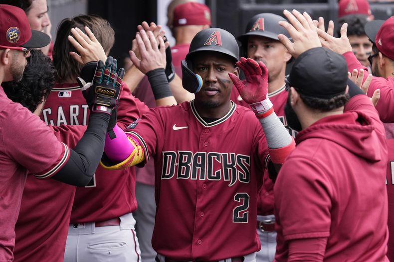 Geraldo Perdomo de los Diamondbacks de Arizona celebra con sus compañeros tras anotar una carrera en el juego ante los Medias Blancas de Chicago, el miércoles 27 de septiembre de 2023. (AP Foto/Nam Y. Huh)