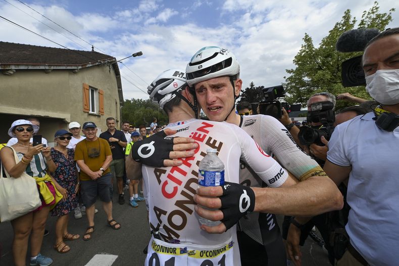 Matej Mohoric, ganador de la 19ma etapa, llora tras ser abrazado por el australiano Ben OConnor al concluir la etapa de 173 kilómetros entre Moirans-en-Montagne y Poligny, Francia el viernes 21 de julio del 2023. (Tim De Waele/Pool Photo via AP)
