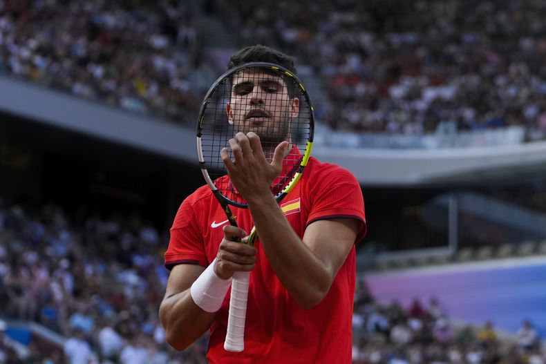 El español Carlos Alcaraz ajusta su raqueta durante el partido de segunda ronda contra el neerlandés Tallon Griekspoor en el tenis de los Juegos Olímpicos de París, el lunes 29 de julio de 2024. (AP Foto/Andy Wong)