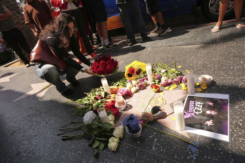 Julia Simonyan coloca flores en la estrella de Ozzy Osbourne en el Paseo de la Fama de Hollywood, el martes 22 de julio de 2025, en Los Ángeles. (Foto AP/Damian Dovarganes)