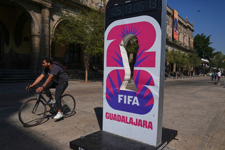 Un ciclista pasa junto a un promocial de la Copa Mundial 2026 en Guadalajara el 25 de febrero del 2026. (AP Foto/Marco Ugarte)