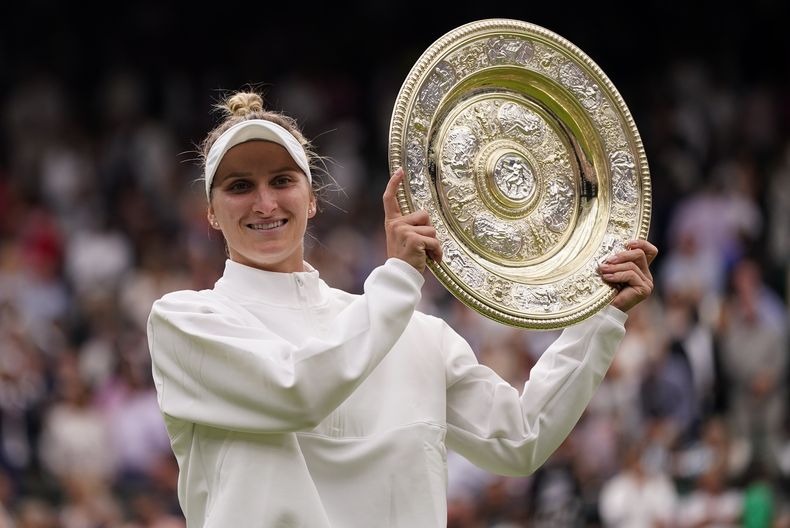 Marketa Vondrousova alza su trofeo luego de vencer a Ons Jabeur en la final femenina de Wimbledon, en Londres, el sábado 15 de julio de 2023. (AP Foto/Alberto Pezzali)