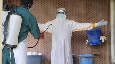 Un trabajador sanitario, vestido con un equipo de protección, es desinfectado por un compañero en el interior de un centro de tratamiento para pacientes con ébola, en Beni, en la provincia de Kivu Norte, en el este de República Democrática de Congo, el 26 de septiembre de 2026. (AP Foto/Sebastien Kitsa Musayi)