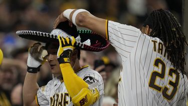 El jugador de los Padres de San Diego Fernando Tatis Jr. (23) pone un sombrero a su compañero Ha-Seong Kim después de que Kim pegara un jonrón de tres carreras en el quinto inning de su juego de béisbol contra los Rojos de Cincinnati, el lunes 1 de mayo de 2023 en San Diego. (AP Foto/Gregory Bull)