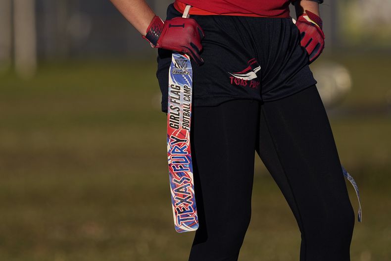 En foto del 10 de diciembre del 2023, una jugadora sostiene su cinturón con la bandera durante un encuentro de fútbol bandera del Texas Fury. (AP Foto/Eric Gay)