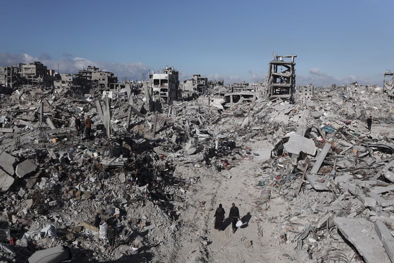 Palestinos caminan entre la destrucción causada por la ofensiva militar israelí en Jabaliya, el lunes 20 de enero de 2025. (AP Foto/Abed Hajjar)