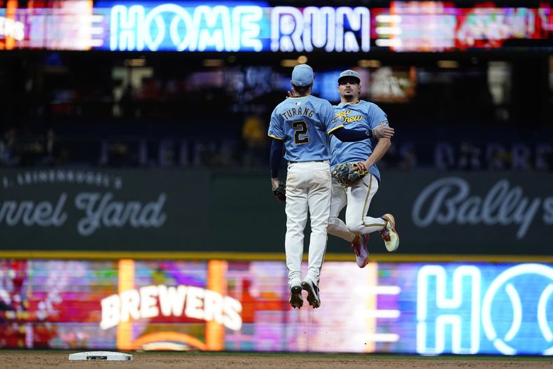 El dominicano Willy Adames y Brice Turang (2), de los Cerveceros de Milwaukee, celebran la victoria sobre los Mets de Nueva York, el viernes 27 de septiembre de 2024 (AP Foto/Aaron Gash)