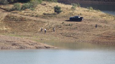 Un equipo policial camina por la orilla del embalse de Arade cerca de Silves, en Portugal, el miércoles 24 de mayo de 2023. Policías portugueses con asistencia de agentes británicos y alemanes reanudaron la búsqueda de Madeleine McCann, una niña británica desaparecida en la región sureña de Algarve hace 16 años. (AP Foto/Joao Matos)