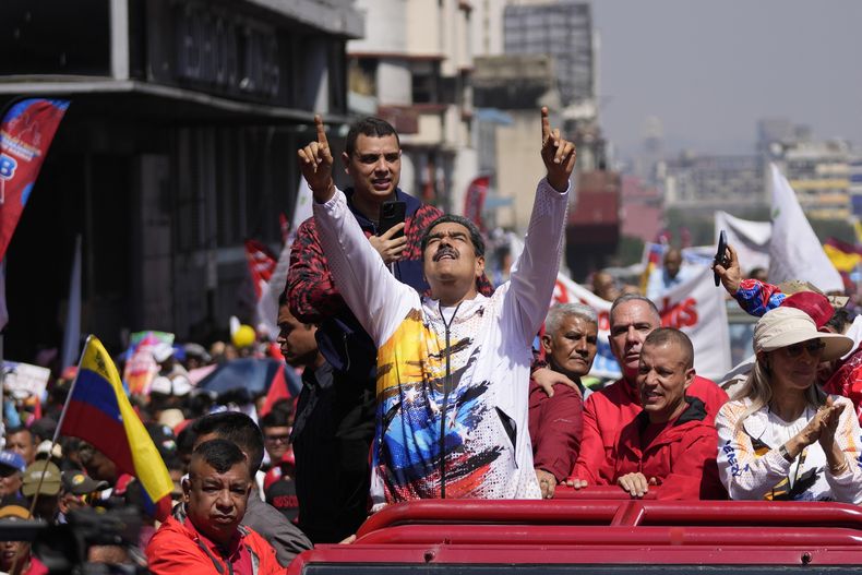 El presidente venezolano Nicolás Maduro señala al cielo mientras lo llevan a la Comisión Nacional Electoral (CNE) con el fin de formalizar su candidatura para postularse nuevamente a la presidencia, el lunes 25 de marzo de 2024, en Caracas, Venezuela. (AP Foto/Matías Delacroix)