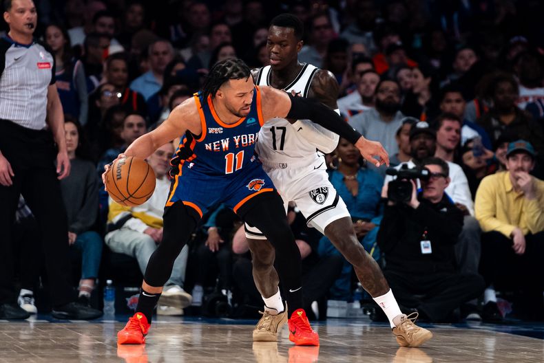 Jalen Brunson (11) de los Knicks de Nueva York frente a la marca de Dennis Schroder (17) de los Nets de Brooklyn, el sábado 23 de marzo de 2024. (AP Foto/Peter K. Afriyie)