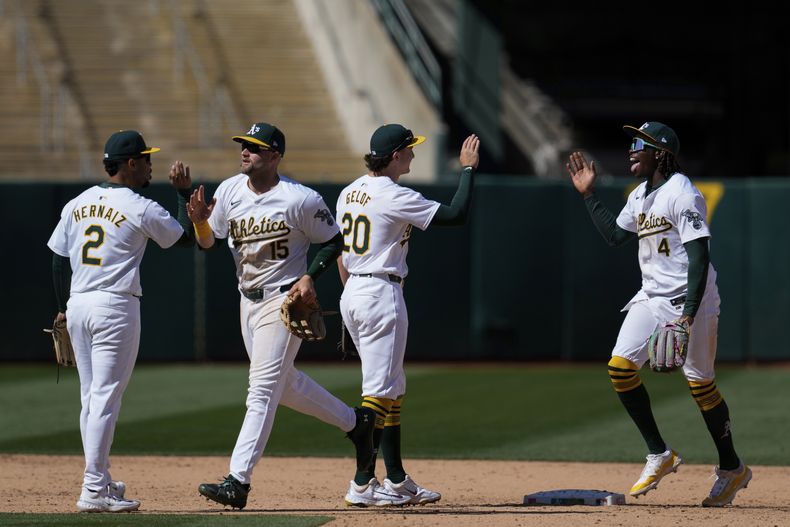 El jardinero derecho de los Atléticos de Oakland Lawrence Butler (derecha) celebra con el segunda base Zack Gelof (20) luego de la victoria sobre los Nacionales de Washington, el domingo 14 de abril de 2024, en Oakland, California. (AP Foto/Godofredo A. Vásquez)