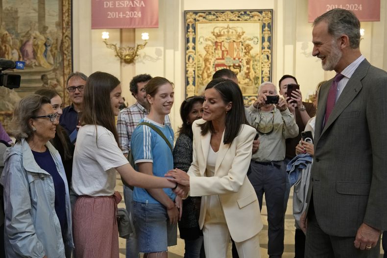 Los reyes de España, Letizia (centro derecha) y Felipe VI (derecha), saludan a turistas durante la inauguración de una exposición sobre el 10mo aniversario del inicio de su reinado, en el Palacio Real, en Madrid, el 20 de junio de 2024. (AP Foto/Bernat Armangue, Pool)