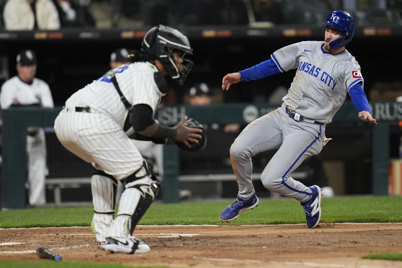 Nick Loftin, derecha, de los Reales de Kansas City, se barre en el plato para anotar carrera con sencillo de Kyle Isbel mientras el receptor Martín Maldonado, de Medias Blancas de Chciago, espera la pelota, durante la quinta entrada del juego de béisbol, el lunes 15 de abril de 2024, en Chicago. (AP Foto/Erin Hooley)
