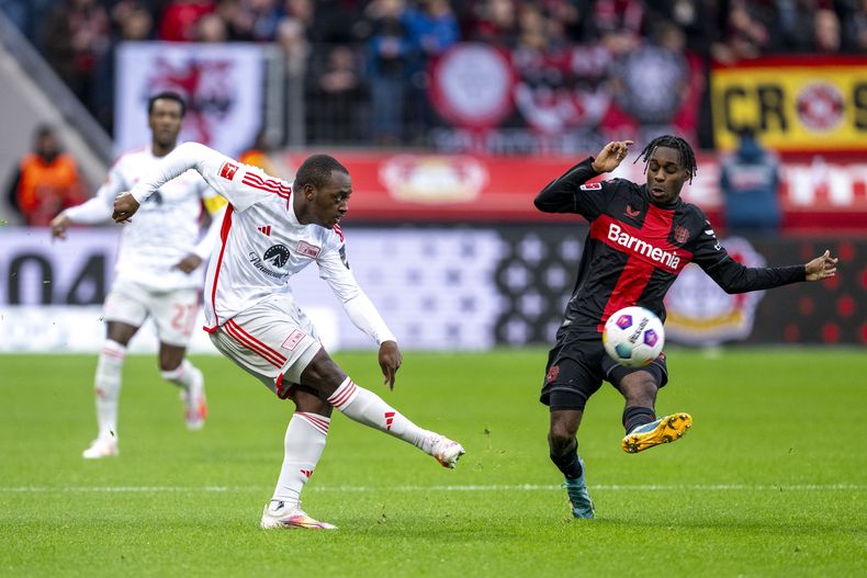 Jerome Roussillon del Unión de Berlín y Jeremie Frimpong del Bayer Leverkusen pelean por el balón en el encuentro de la Bundesliga el domingo 12 de noviembre del 2023. (David Inderlied/dpa via AP)