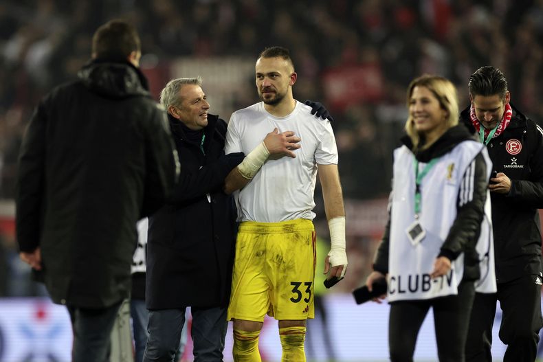 Klaus Allofs (2do de izquierda a derecha), director deportivo del Fortuna Düsseldorf, felicita al portero Florian Kastemeier, tras la tanda de penales que significó el triunfo ante St. Pauli en los cuartos de final de la Copa de Alemania (Christian Charisius/dpa via AP)