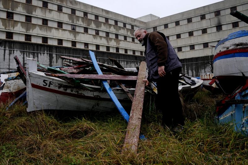 El preso Andrea Volonghi de la cárcel Opera de máxima seguridad de Milán revisa madera de un barco naufragado de inmigrantes almacenada en la cárcel el virnes 9 de febrero de 2024. Presos de Opera usan la madera para crear instrumentos musicales que la Orquesta del Mar usóen su debut en el Teatro alla Scala. (Foto/Antonio Calanni)