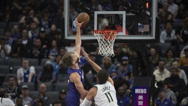 El alero de los Kings de Sacramento Domantas Sabonis anota superando al pívot de los Bucks de Milwaukee Brook Lopez en el encuentro de la NBA del martes 12 de marzo del 2024. (AP Foto/José Luis Villegas)