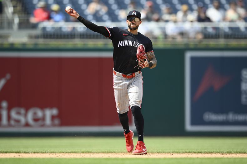 Carlos Correa de los Mellizos de Minnesota saca out a Nick Senzel de los Nacionales de Washington, el miércoles 22 de mayo de 2024, en Washington. (AP Foto/Nick Wass)