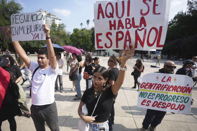 Manifestantes sostienen letreros durante una protesta contra la gentrificación, luego de que el incremento en la presencia de personas que trabajan a distancia ha provocado aumentos de precios y una mayor demanda de viviendas en vecindarios como Condesa y Roma, el viernes 4 de julio de 2025, en Ciudad de México. (AP Foto/Fernando Llano)