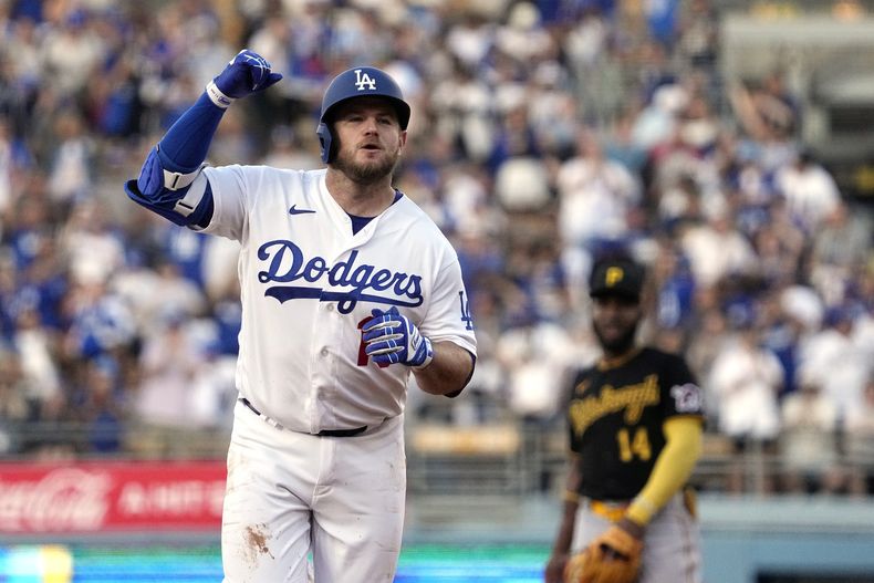 Max Muncy, de los Dodgers de Los Ángeles, celebra mientras corre a tercera base tras sacudir un jonrón solitario, mientras el campocorto de los Piratas de Pittsburgh, Rodolfo Castro, observa en segundo plano, en el segundo inning del juego de la MLB que enfrentó a los dos equipos, el 3 de julio de 2023, en Los Ángeles. (AP Foto/Mark J. Terrill)