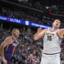 El pívot serbio Nikola Jokic, de los Nuggets de Denver, alcanza un rebote frente a Jock Landale, de los Suns de Phoenix, en el encuentro de playoffs disputado el martes 9 de mayo de 2023 (AP Foto/David Zalubowski)