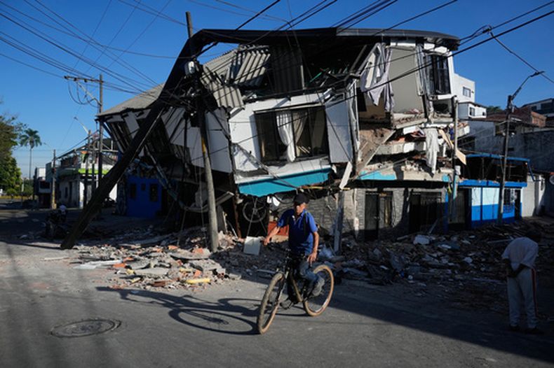 Un vecino pasa en bicicleta frente a viviendas dañadas un día después que un sismo sacudiera Pereira, Colombia, el martes 11 de agosto de 2026. (Foto AP/Fernando Vergara)
