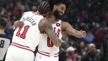 DeMar DeRozan, de los Bulls de Chicago, abraza a Coby White, quien encestó en el partido ante los Grizzlies de Memphis, el sábado 20 de enero de 2024 (AP Foto/Charles Rex Arbogast)