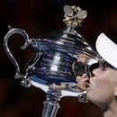 ARCHIVO - Caroline Wozniacki besa el trofeo de campeona del Abierto de Australia tras derrotar a Simona Halep en la final, el sábado 27 de enero de 2018. (AP Foto/Dita Alangkara)