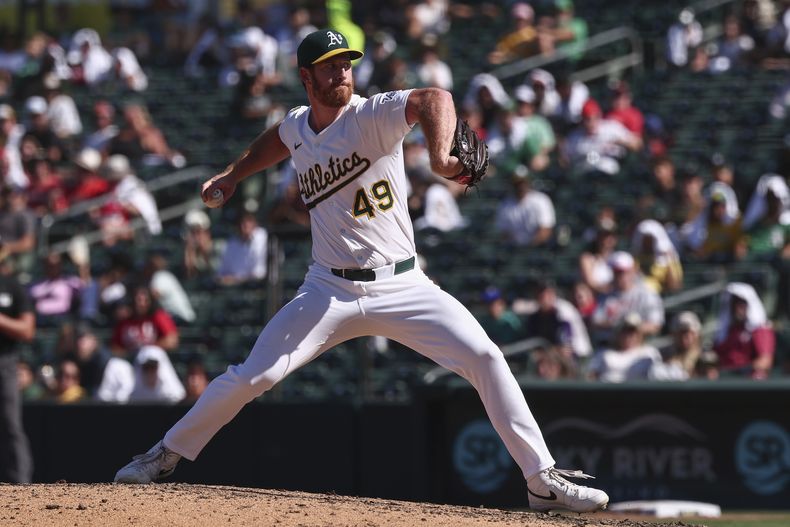 El lanzador de los Atléticos, Michael Kelly, lanza contra los Rojos de Cincinnati durante la novena entrada de un juego de béisbol el domingo 14 de septiembre de 2025, en West Sacramento, California. (AP Photo/Sara Nevis)