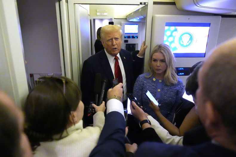 ARCHIVO - El presidente Donald Trump habla con la prensa a bordo del Air Force One en ruta a Miami desde la Base Conjunta Andrews, Maryland, el 27 de enero de 2025, mientras lo escucha la secretaria de Prensa de la Casa Blanca, Karoline Leavitt. (AP Foto/Mark Schiefelbein, archivo)