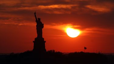 americateve | La Estatua de la Libertad vista desde Nueva York con la puesta del sol al fondo durante el solsticio de verano, el d&iacute;a m&aacute;s largo del a&ntilde;o, el mi&eacute;rcoles 21 de junio de 2006. La Estatua de la Libertad ser&aacute; reabierta el domi