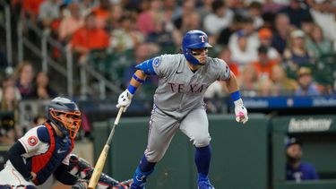 Alejandro Osuna, de los Rangers de Texas, a la derecha, observa su sencillo impulsor frente al receptor de los Astros de Houston, Yainer Díaz, durante la cuarta entrada de un partido de béisbol el sábado 1 de agosto de 2026, en Houston. (Foto AP/David J. Phillip)