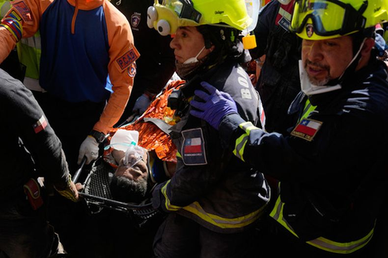 Rescatistas chilenos trasladan a Alberto Gil Flores tras ser rescatado de entre los escombros, ocho días después de quedar atrapado tras los sismos consecutivos ocurridos en Catia La Mar, Venezuela, el jueves 2 de julio de 2026. (AP Foto/Fernando Vergara)